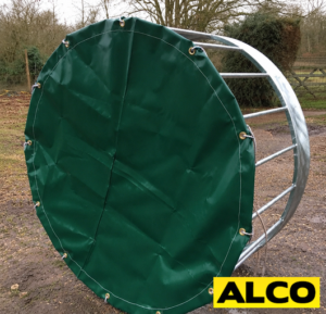 Custom-made outdoor cover fitted over a sheep ring feeder to protect hay and feed from weather.