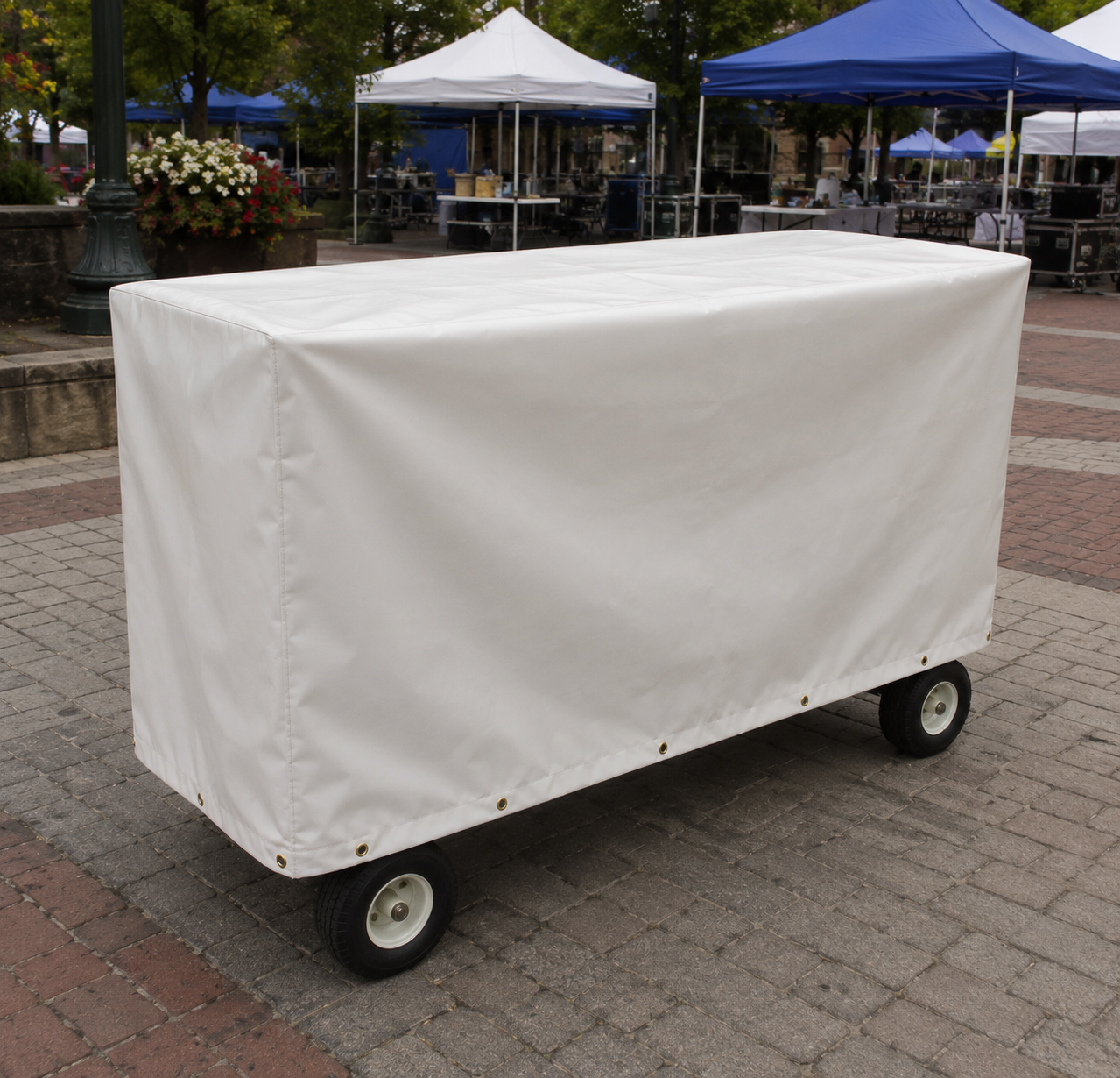 Custom-made waterproof covers fitted over outdoor stanchion carts to protect equipment from weather.