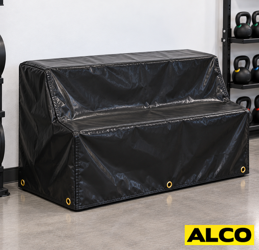 Heavy-duty covers fitted over gym equipment racks to protect weights and machinery in a commercial facility.