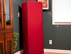 Red fabric cover concealing a tall gun safe in a living room