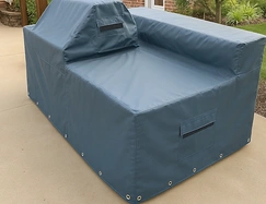 Gray vinyl cover fitted over an outdoor grill island kitchen on a patio